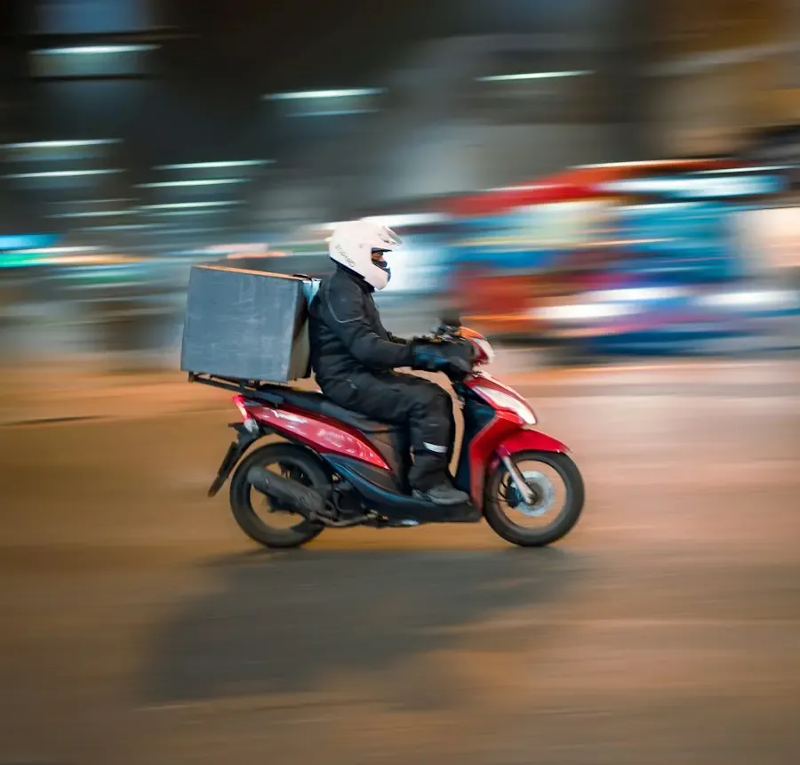 Repartidor en moto llevando un pedido por la ciudad